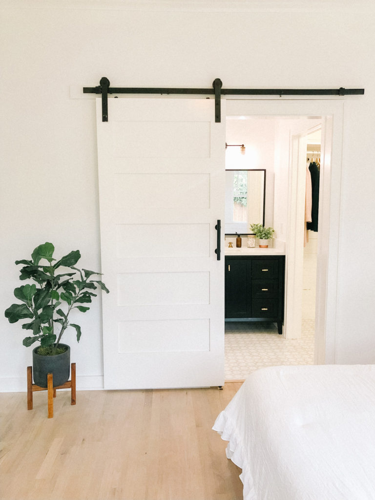 white bedroom sliding barn door master bathroom suite | 102-year-old fixer upper house renovation | mid century modern Scandinavian home design | house flip reno